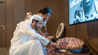Sheikh Shakhbout examines a piece of traditional art at one of the African pavilions.