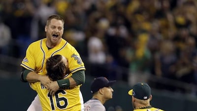 Oakland Athletics catcher Stephen Vogt, top, is mobbed by teammates after his game-winning, bases-loaded single in the bottom of the ninth in a 1-0 win over Detroit. Marcio Jose Sanchez / AP Photo