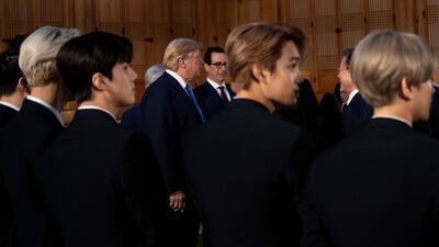 Members of K-pop band Exo stand while US President Donald Trump and US Secretary of the Treasury Steven Mnuchin and South Korea's President Moon Jae-in wait for a working dinner at the tea house on the grounds of the presidential Blue House in Seoul. AFP