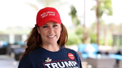 Nikki Cruz wears a MAGA cap, Trump shirt and pin as she watches the results come in at Trump International Golf Club.