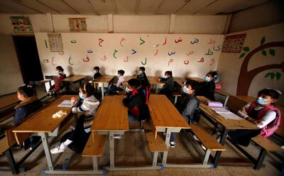Students wearing protective face masks sit in a classroom following the reopening of their school in Baghdad November 29, 2020, after months of closure due to the spread of the coronavirus. Reuters
