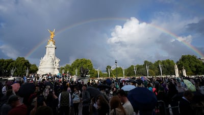 People outside Buckingham Palace in London as a double rainbow appears in the sky after Queen Elizabeth II was placed under medical supervision because doctors were concerned for her health. AP