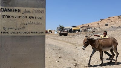 A Palestinian boy walks a donkey along a road in the West Bank area of Tubas – which Israel has designated a firing range – on July 19, 2016. Jaafar Ashtiyeh/AFP