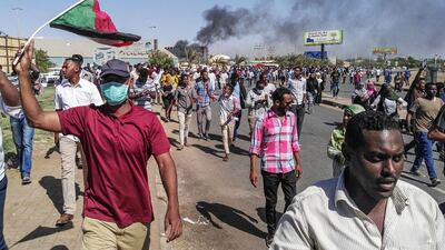 Sudanese protesters hold waive the national flag as they march towards the army headquarters in the capital Khartoum on April 6, 2019. AFP