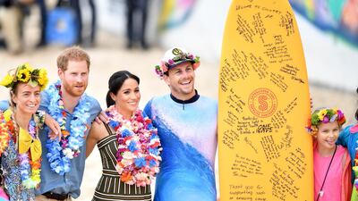 Prince Harry and Meghan pose for a photograph with members of OneWave. EPA