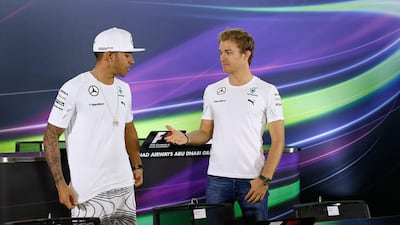 Mercedes-GP driver Lewis Hamilton, left, thinks twice about shaking hands with teammate Nico Rosberg at the Yas Marina Circuit in Abu Dhabi on Thursday. Valdrin Xhemaj / EPA