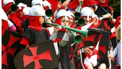 Two-year-old 'knight' Vinnie Walters, bottom right, sleeps through a cacophony of vuvuzela noise created by his fellow knights of St George's Church during a parade through Chichester, England as part of the celebrations to mark Queen Elizabeth II's Diamond Jubilee on Saturday June 2, 2012. PA Wire