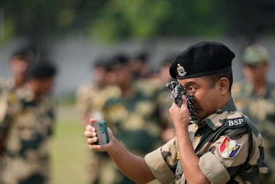 An Indian Border Security Force soldier takes a video of a wreath-laying ceremony for his colleague Lal Fam Kima in Jammu on Thursday. Lal Fam Kima was killed when Indian and Pakistani soldiers exchanged gunfire in disputed Kashmir. AP