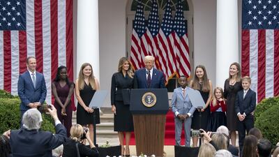 US President Donald Trump, First Lady Melania Trump, Supreme Court Justice nominee Amy Coney Barrett and her family stand on stage following a ceremony in the Rose Garden of the White House in Washington. Bloomberg