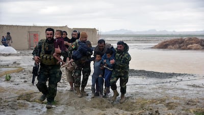 Afghan security forces carry children after flood affected their homes in Arghandab district of Kandahar province, on March 2, 2019. AFP