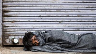 A man sleeps in front of a closed shop in New Delhi, India, during a government-imposed lockdown to combat the spread of the coronavirus. AFP