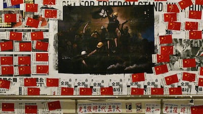 A pro-democracy poster and Chinese flags are seen on the wall of a tunnel in the Tsim Sha Tsui district. AFP