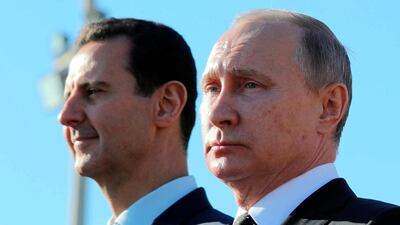 Vladimir Putin, right, and Bashar Al Assad watch a military parade in Syria, on Monday. Mikhail Klimentyev, Sputnik, Kremlin Pool Photo via AP
