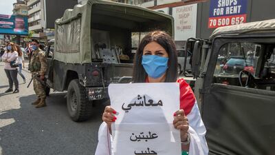 A supporter of Lebanese Christians parties carry placards with Arabic word read " My salary is not enough to buy two cans of milk " during a protest against the collapsing Lebanese pound currency and the price hikes of goods, in Al-Zouk area, northern Beirut, Lebanon. EPA