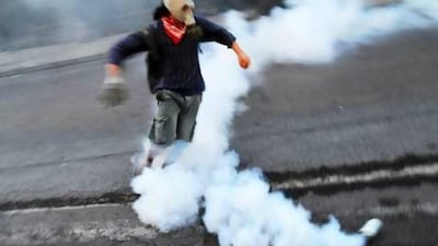 A Turkish protestor wearing a gas mask runs from a tear gas canister during clashes early on the morning of May 31, 2013 as part of a protest against the demolition of Taksim Gezi Park, in Taksim Square in Istanbul. Police reportedly used tear gas on early May 31 to disperse a group, who were standing guard in Gezi Parki to prevent the Istanbul Metropolitan Municipality from demolishing the last remaining green public space in the center of Istanbul as a part of a major Taksim renewal project. AFP PHOTO/BULENT KILIC