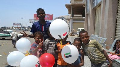 A group of children are pictured next to Ahaml Mall in the southern city of Aden after receiving brand new clothes for Eid Al Adha from the Emirates Red Crescent. Mohammed Al Qalisi/The National