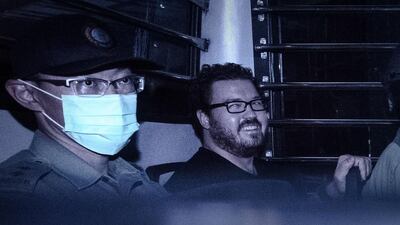 British banker Rurik Jutting, charged with the murders of two women, smiles as he sits in a prison van leaving a Hong Kong court after his hearing on November 10, 2014. Philippe Lopez/AFP Photo