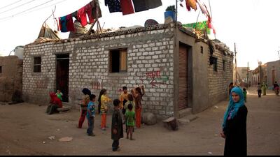 Palestinian refugee children play next to a house in Gezirat al-Fadel village.