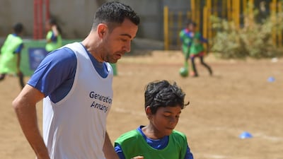 Former Spain international midfielder Xavi plays with Indian children a football game in Mumbai.
