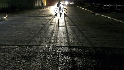 A Palestinian boy, on his bicycle, casts a shadow in the street during a power outage in Al Shateaa refugee camp in Gaza City. Mohammed Saber / EPA