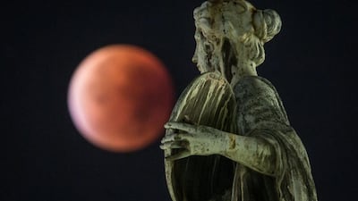 A so-called “blood moon” can be seen behind a statue during a total lunar eclipse in Frankfurt am Main, western Germany. Frank Rumpenhorst / AFP Photo