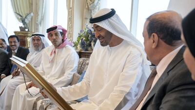 Sheikh Mohamed bin Zayed receives a gift of a framed photograph from Sultan Al Burkani. Seen with Sheikh Mansour bin Zayed. Mohamed Al Hammadi / Ministry of Presidential Affairs
