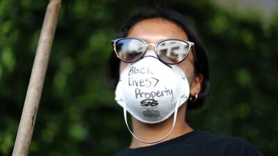 A woman sweeping outside looted stores wears a protective mask that reads: "Black Lives are greater than property" during nationwide unrest following the death in Minneapolis police custody of George Floyd, amid the coronavirus outbreak in Santa Monica, California, US, June 1, 2020. Reuters