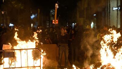 Catalan protesters gesture behind barricades in flames after a demonstration called by the local Republic Defence Committees (CDR) in Barcelona on October 17, 2019. AFP / LUIS GENE