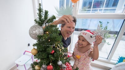Alex Broun with his daughter Naraya decorate a Christmas tree at their home.
