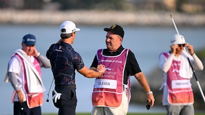 Thorbjorn Olesen of Denmark and his caddie Dominic Bott celebrate victory on the 18th green at Al Hamra Golf Club. Getty Images