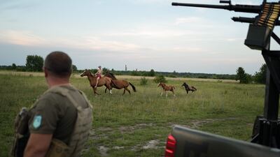 A bare-chested rider with horses passes a Ukrainian anti-aircraft unit in the Khmelnytsky region of Ukraine. AFP