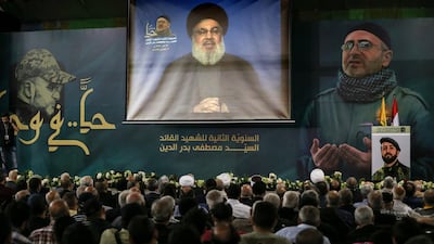 Supporters of Hezbollah watch Secretary General Hassan Nasrallah on a big screen as he delivers a speech from an undisclosed location on May 14 2018. Nabil Mounzer / EPA