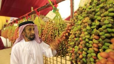 Abdulla Abdulla al Mazrouei, the oldest farmer in Liwa checks the quality of dates displayed at Liwa dates festival in Western region of Abu Dhabi.