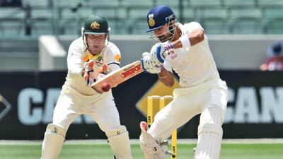 Indian batsman Virat Kohli, right, cuts a ball away as Australian wicketkeeper Brad Haddin looks on during the final day of the third cricket Test played at the Melbourne Cricket Ground (MCG), in Melbourne on December 30, 2014. AFP PHOTO/William WEST