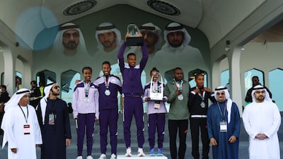 Ethiopia's Nibret Melak and Anchinalu Dessie celebrate on the podium with the trophies after winning the men's elite race and the women's elite race alongside second placed Ethiopia's Yasin Haji and Muliye Dekebo and third placed Rwanda's John Hakizimana and Ethiopia's Fantu Worku