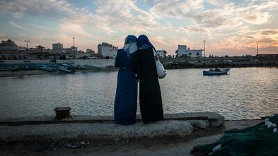Girls watch the sun set at the harbor in Gaza City. While living in Gaza is undeniably tough, being a woman there is harder.