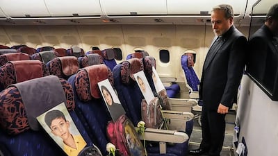 Iran's Foreign Minister Abbas Araghchi looks at the photos of the school pupils killed by American fire in Madrasa Minab in Iran while aboard a plane on his way to Pakistan for talks with US peace delegates. AFP