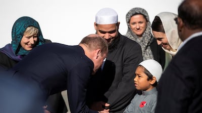 Prince William greets a junior Muslim community member as Ms Ardern looks on. Reuters