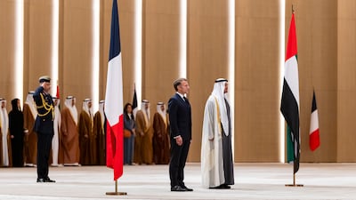 Sheikh Mohamed and Mr Macron stand for the national anthem during an official visit reception in Abu Dhabi. UAE Presidential Court