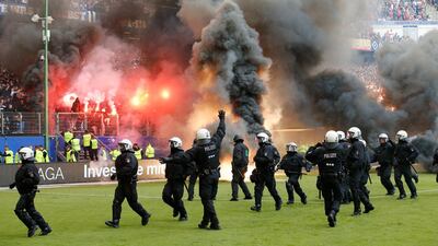 Police officers stand on the pitch when Hamburg fans light fireworks when their team relegates during the German Bundesliga soccer match between Hamburger SV and VfL Borussia Moenchengladbach in Hamburg, Germany, on May 12, 2018. Michael Sohn / AP Photo