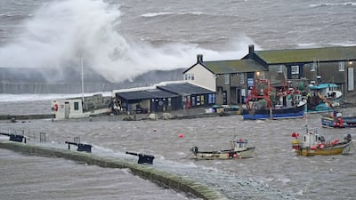 Waves crash over the sea wall at the harbour in Lyme Regis in Dorset, south-west England. PA