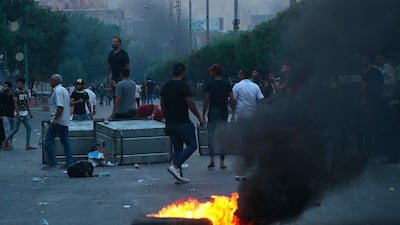 Protesters burn tyres and block a street during a demonstration in Baghdad. AP Photo