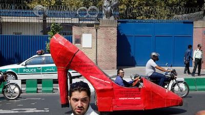 An Iranian man with his mobile shoeshine stall passes in front of the British embassy in Tehran. British Foreign Secretary Philip Hammond arrived at the embassy as Britain reopened its diplomatic presence in Tehran four years after it was attacked by protesters. Abedin Taherkenareh / EPA