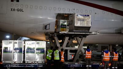 Employees unload shipping containers of the AstraZeneca Covid-19 vaccine from the US from an Aero Union airplane at Benito Juarez International Airport in Mexico City. AFP