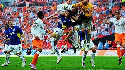 David Marshall, the Cardiff goalkeeper, tries to punch the ball away to safety against Blackpool at Wembley yesterday.