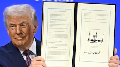 TOPSHOT - US President Donald Trump holds a signed founding charter at the "Board of Peace" meeting during the World Economic Forum (WEF) annual meeting in Davos on January 22, 2026. US President Donald Trump will show off his new "Board of Peace" at Davos on January 22, 2026 burnishing his claim to be a peacemaker a day after backing off his own threats against Greenland. Originally meant to oversee the rebuilding of Gaza after the war between Hamas and Israel, the board's charter does not limit its role to the Strip, and has sparked concerns that Trump wants it to rival the United Nations. (Photo by Fabrice COFFRINI / AFP)