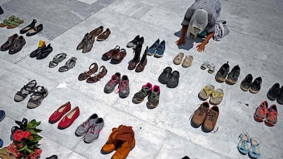 A woman prays in front of hundreds of shoes that were displayed in memory of those killed by Hurricane Maria in front of the Puerto Rican Capitol, in San Juan. Hurricane Maria, which pummeled Puerto Rico in September 2017, is likely responsible for the deaths of more than 4,600 people, some 70 times more than official estimates, US researchers said Tuesday. Ricardo Arduengo / AFP