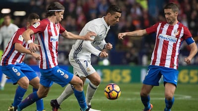 Real Madrid’s Portuguese forward Cristiano Ronaldo, centre, vies with Atletico Madrid’s Brazilian defender Filipe Luis. Curto de la Torre / AFP