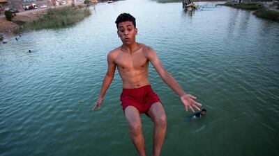 A boy dives in a river near the port in Basra, Iraq.