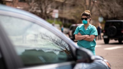 Healthcare workers stand in the street in counter-protest to hundreds of people who gathered at the State Capitol to demand the stay-at-home order be lifted in Denver, Colorado, US. Reuters